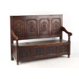 Property of a lady - a late 18th century George III oak settle with box seat, later carved with