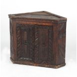 Property of a lady - an oak low corner cabinet, with later carved decoration, 24.75ins. (63cms.)