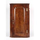 Property of a deceased estate - an early 18th century walnut corner wall cabinet with shaped fielded