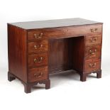 An early 19th century Regency period mahogany kneehole desk, with recessed cupboard flanked by seven