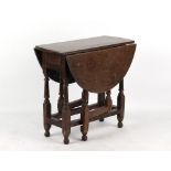 Property of a gentleman of title - an early 18th century oak oval topped gate-leg table, with end