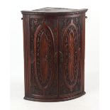 Property of a lady - a George III oak bow-fronted corner wall cupboard with later carved decoration,