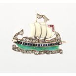 An unusual enamel ruby sapphire & diamond brooch modelled as a viking ship, with white enamel