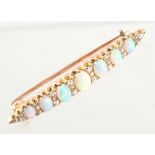 An unmarked yellow gold opal & diamond bar brooch, set with seven graduated oval opals alternating