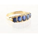 An 18ct yellow gold sapphire five stone ring, the vibrant blue cushion cut sapphires flanked by