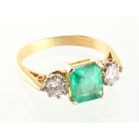 A yellow gold emerald & diamond three stone ring, the octagonal cut emerald weighing approximately