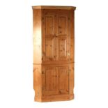 Property of a gentleman - a pine two-part freestanding corner cabinet, with fielded panels,