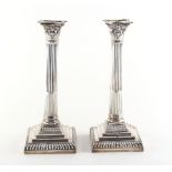 Property of a lady - a pair of late Victorian silver Corinthian column candlesticks, with weighted