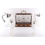 Property of a lady - an oak tantalus with three decanters; together with two cut glass decanters