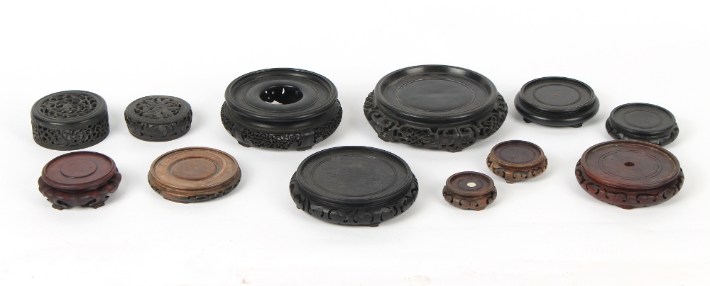 Property of a gentleman - ten Chinese carved wooden stands; together with two carved & pierced