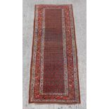 Property of a lady - an antique Hamadan long rug, with red boteh field, 116 by 43ins. (295 by