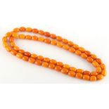 Property of a lady - a butterscotch amber bead necklace, the uniform oval beads each approximately