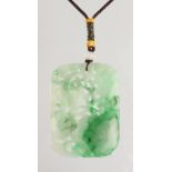 A large Chinese carved jadeite lotus & lingzhi pendant, the translucent stone with apple green