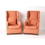 Property of a gentleman - a pair of early 20th century upholstered wing armchairs with bun feet &