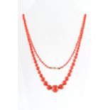 A coral bead necklace, the largest of the 109 graduated beads measuring approximately 14.5mm, the