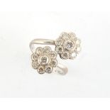 Property of a deceased estate - an 18ct white gold diamond twin flowerhead cluster crossover ring,