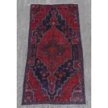A Hamadan woollen hand-made rug with navy ground, 86 by 42ins. (220 by 117cms.).