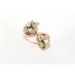 Property of a deceased estate - an unmarked yellow gold diamond twin flowerhead crossover ring,