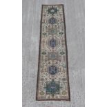 A Hamadan woollen hand-made runner with beige ground, 112 by 26ins. (284 by 66cms.).