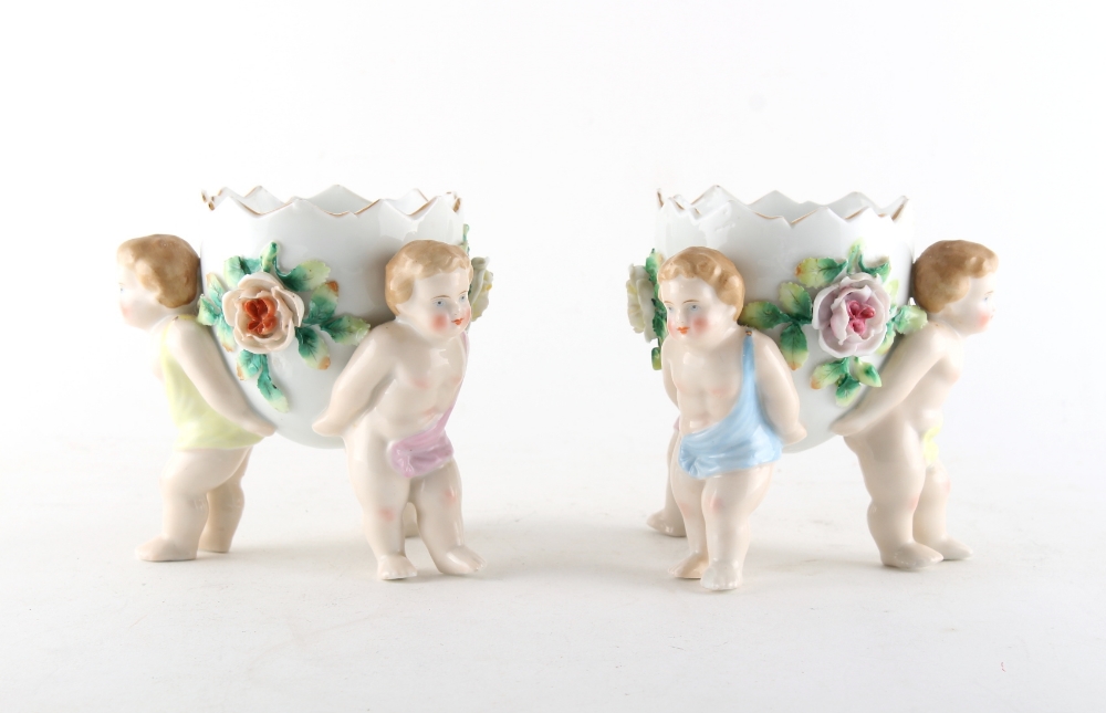 Property of a lady - a pair of Continental porcelain planters with putti supports, each 4.75ins. (