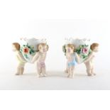 Property of a lady - a pair of Continental porcelain planters with putti supports, each 4.75ins. (