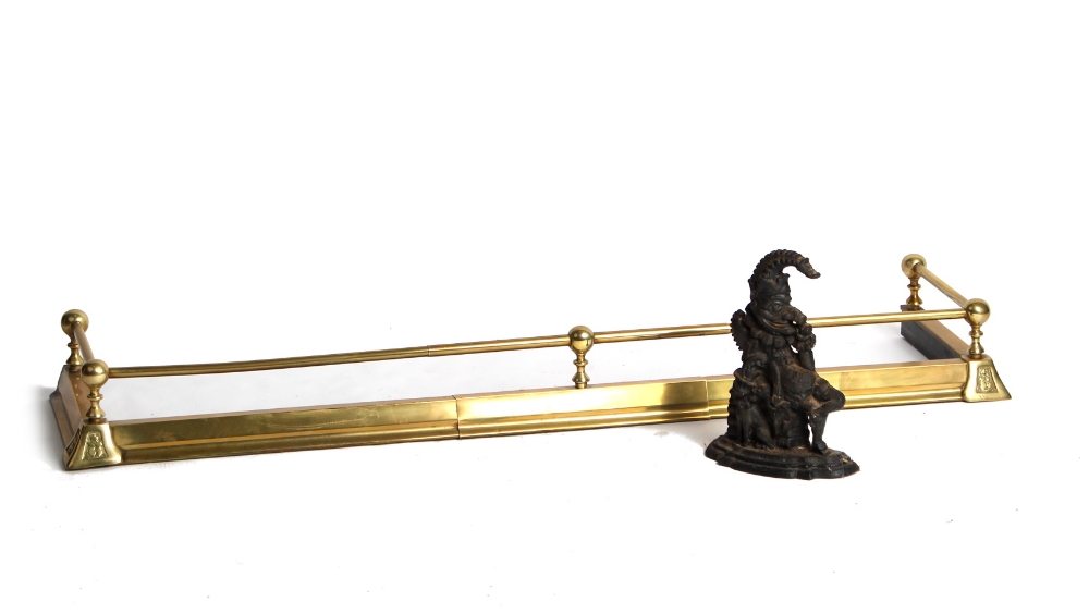 Property of a lady - an Edwardian brass adjustable fender; together with a cast iron Mr Punch
