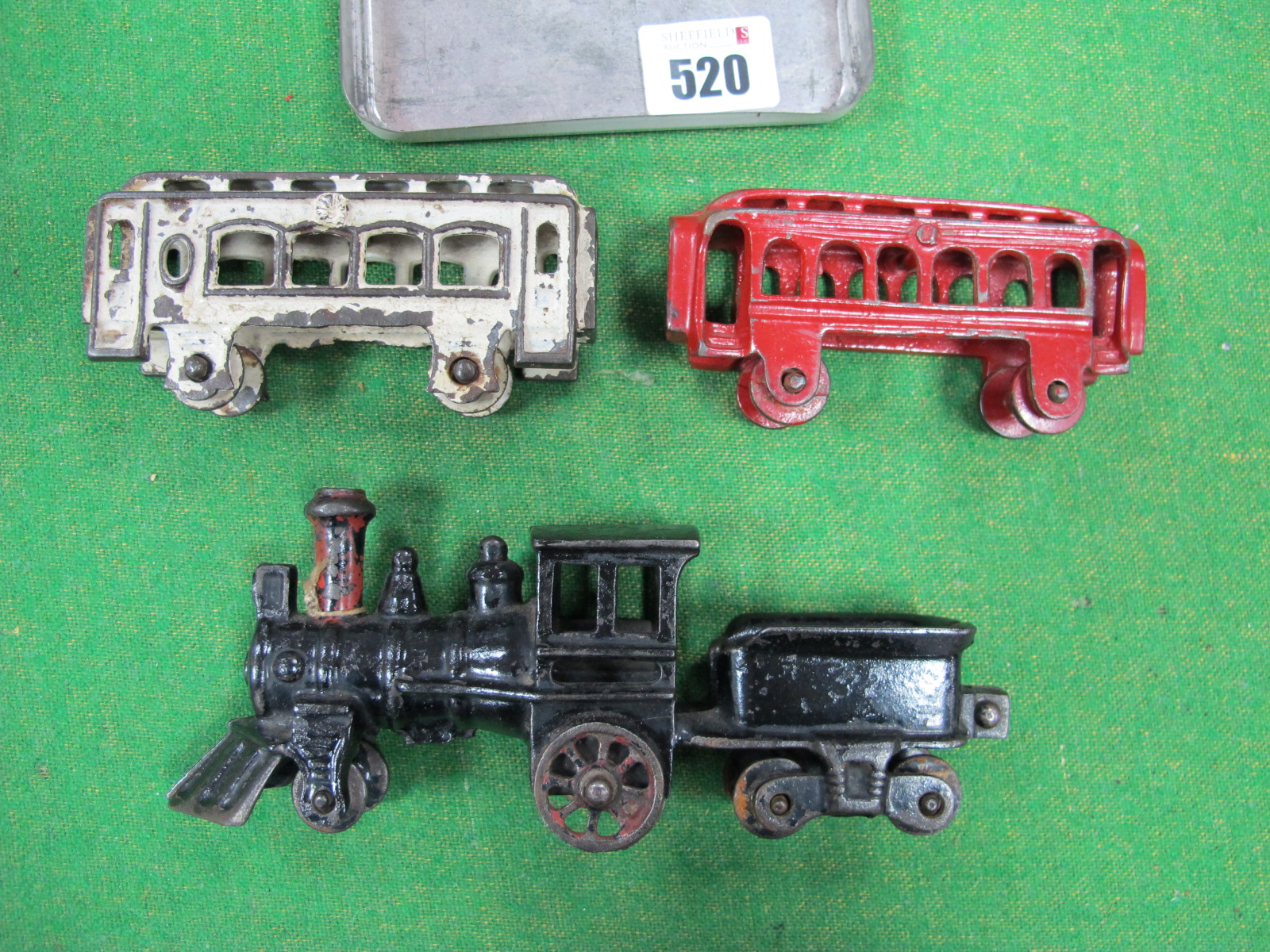 An American Cast Iron Train, with two carriages, appears unbroken, but playworn, overall length