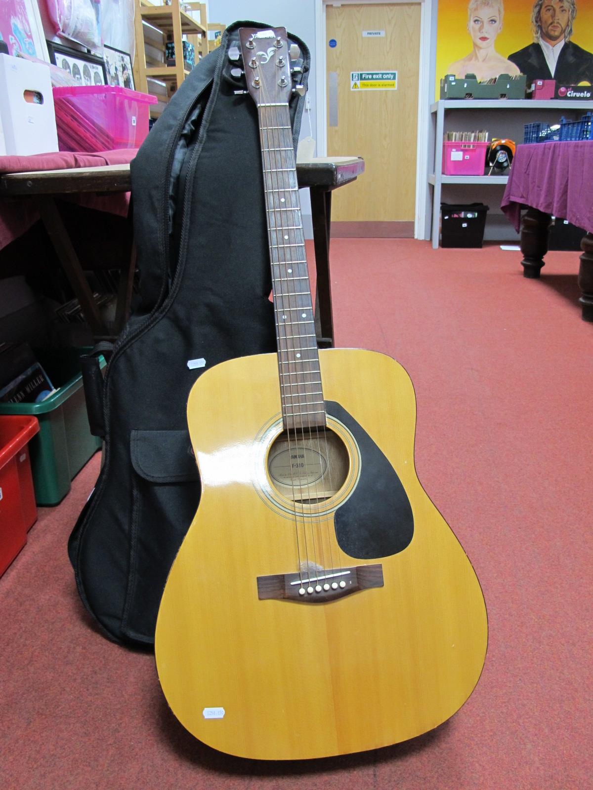 A Yamaha F-310 Acoustic Guitar, with soft carry case, floor stand.