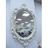 A Pair of White Painted Metal Framed Oval Mirrors, with gilt highlights, 75cm high overall.