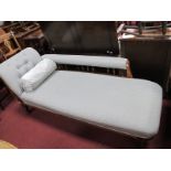 Edwardian Walnut Chaise Lounge, having spindle back, turned legs, re-upholstered in a grey fabric,