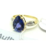An 18ct Gold Pear Shape Tanzanite and Diamond Set Ring, high four claw set to the centre, between