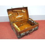 An Early XX Century Leather Bound Suitcase, the interior fitted with four ivorine backed brushes,