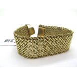 A Wide Textured Bracelet, of uniform woven design with ropetwist edge, to concealed snap clasp,