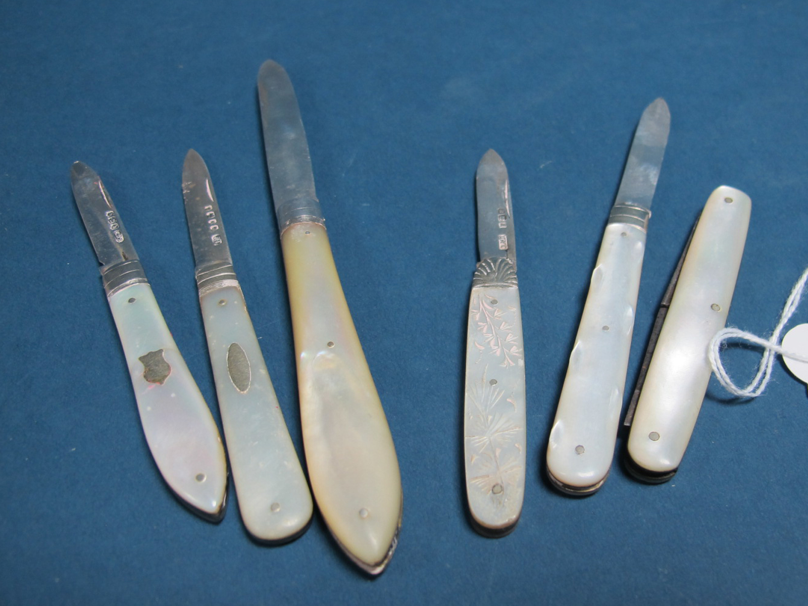 Four Hallmarked Silver and Mother of Pearl Single Blade Folding Fruit Knives; together with a larger