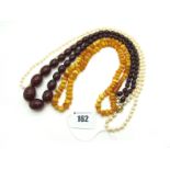 A Long Single Strand Pearl Bead Necklace, of uniform design, knotted to clasp stamped "9ct"; A