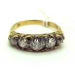 A Victorian Five Stone Diamond Ring, the graduated old cut stones claw set within scroll carved