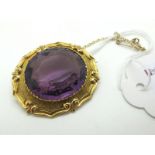 A Large Amethyst Single Stone Brooch, oval collet set within shaped setting.