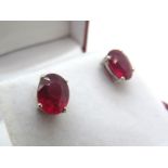A Pair of Modern Single Stone Ruby Earstuds, oval four claw set, stamped "925".