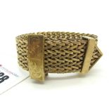 A 9ct Gold Bracelet, of wide uniform textured design, with fold over clasp, leaf scroll engraved.