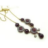 An Antique Style Garnet and Seed Pearl Set Necklace, of triple cluster design, with teardrop between