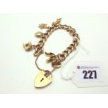 A 9ct Gold Curb Link Charm Bracelet, to 9ct gold heart shape padlock clasp, suspending five assorted