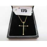 A Delicate Cross Pendant, with claw set highlights, stamped "750", on 9ct gold fine chain.