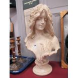 An Art Nouveau Style Bust of a Young Girl, with flowers in her hair, on circular socle base, 56cm