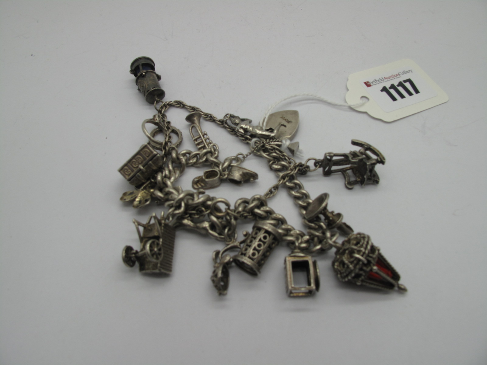 A Curb Link Charm Bracelet, to heart shape padlock clasp, suspending assorted charm pendants;