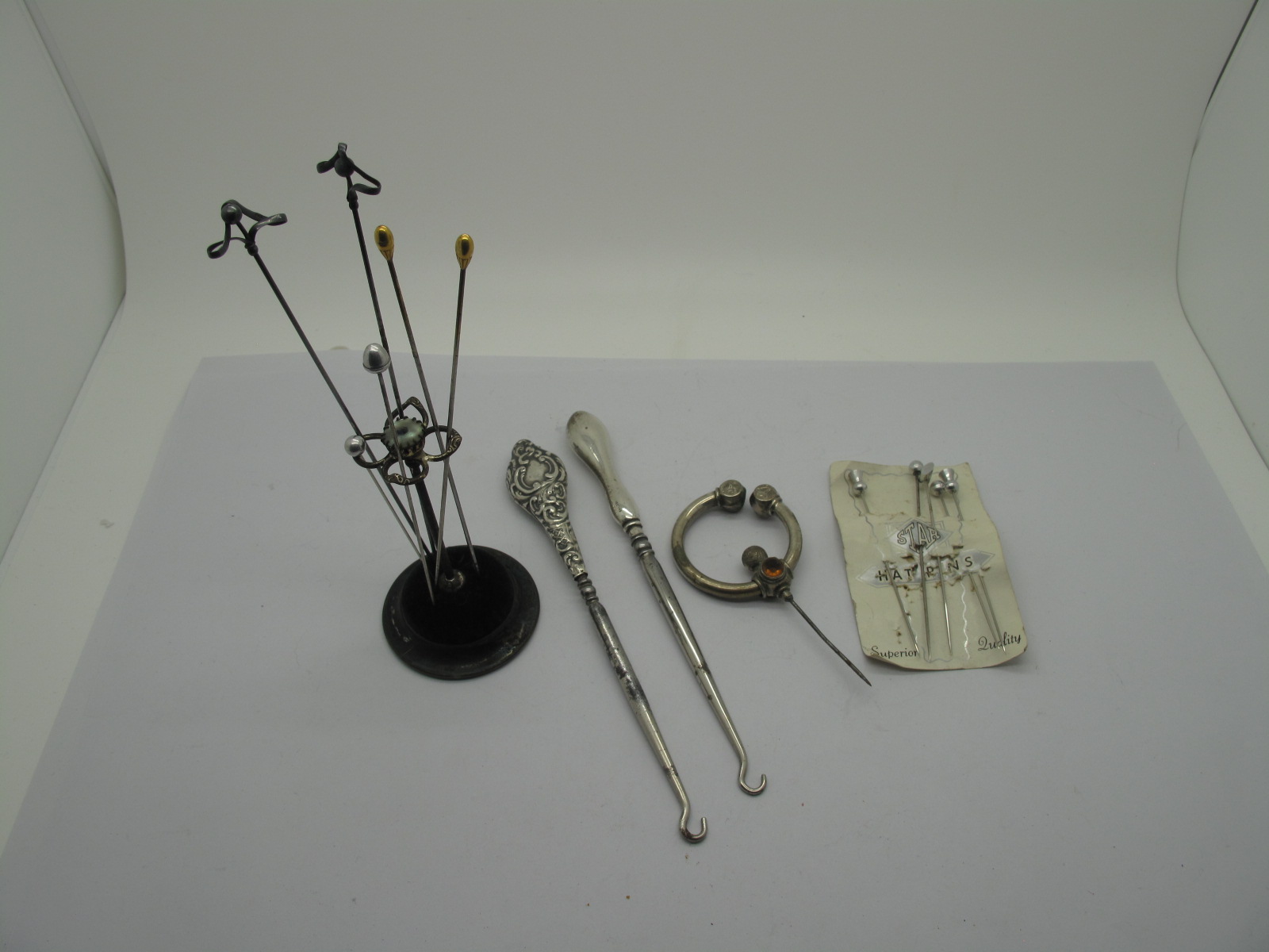 A Hat Pin Stand; together with assorted pins, a Celtic pin brooch and two hallmarked silver