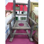 A XIX Century Ash and Elm Child's Commode Rocking Chair with rail supports, seat with a circular