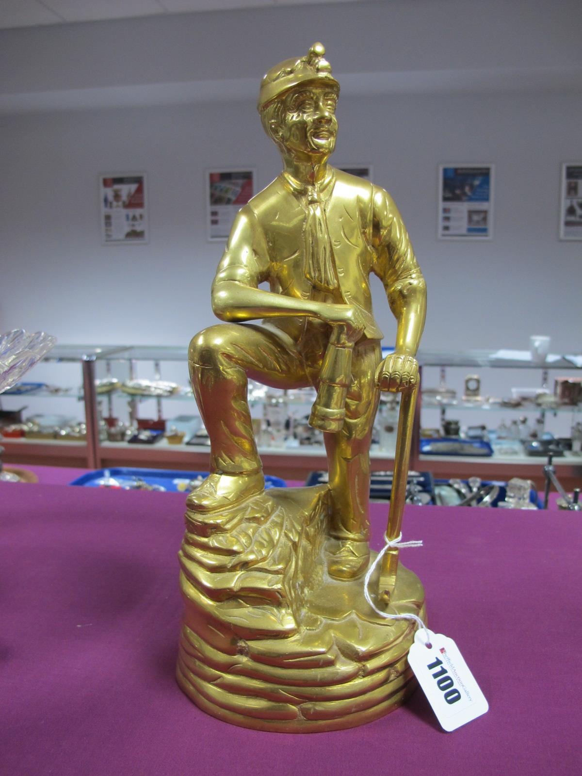 A Brass Figure of a Coal Miner, leaning on a pick axe, holding a lamp, 31cm high.