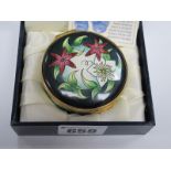 A Moorcroft Circular Enamel Trinket Pot, the hinged lid painted with Hellebores, 5.6cm diameter,