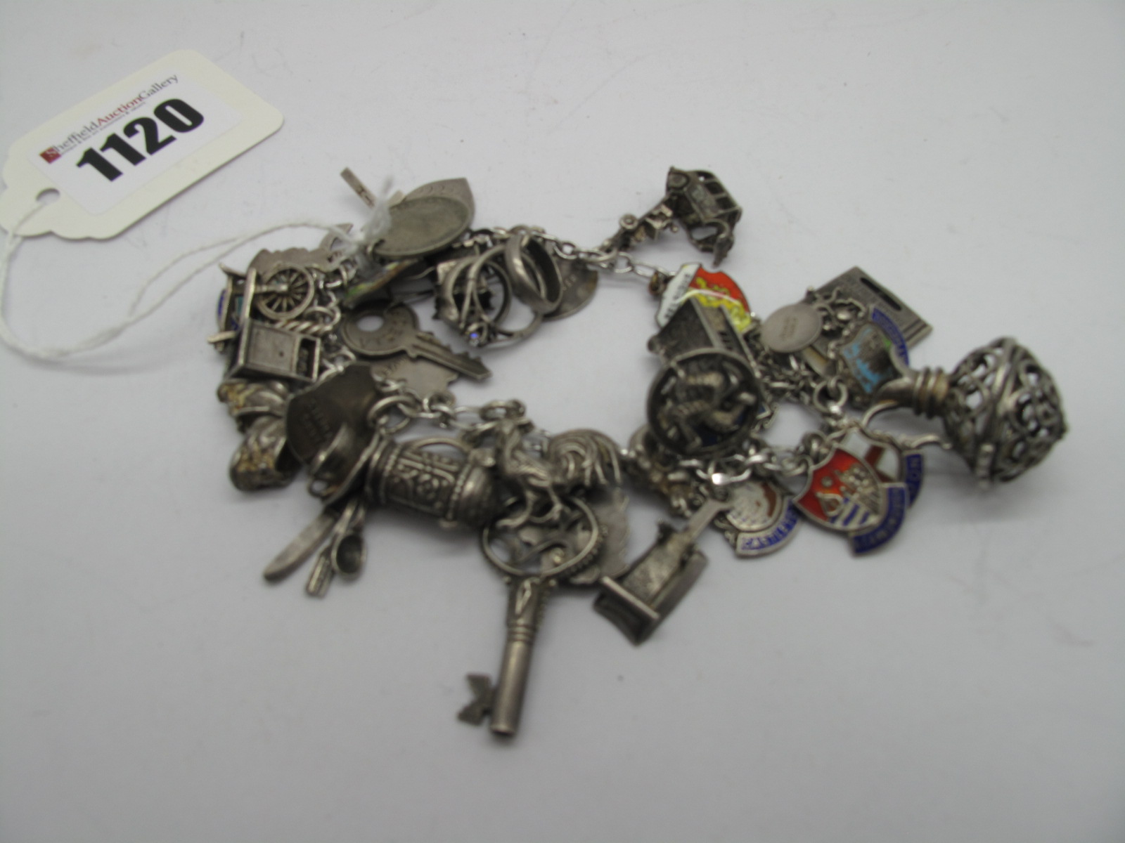 A Charm Bracelet, suspending numerous novelty charm pendants, including taxi cab, British