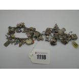 A Charm Bracelet, suspending numerous novelty charm pendants, including carriage, dog, dragon, St.